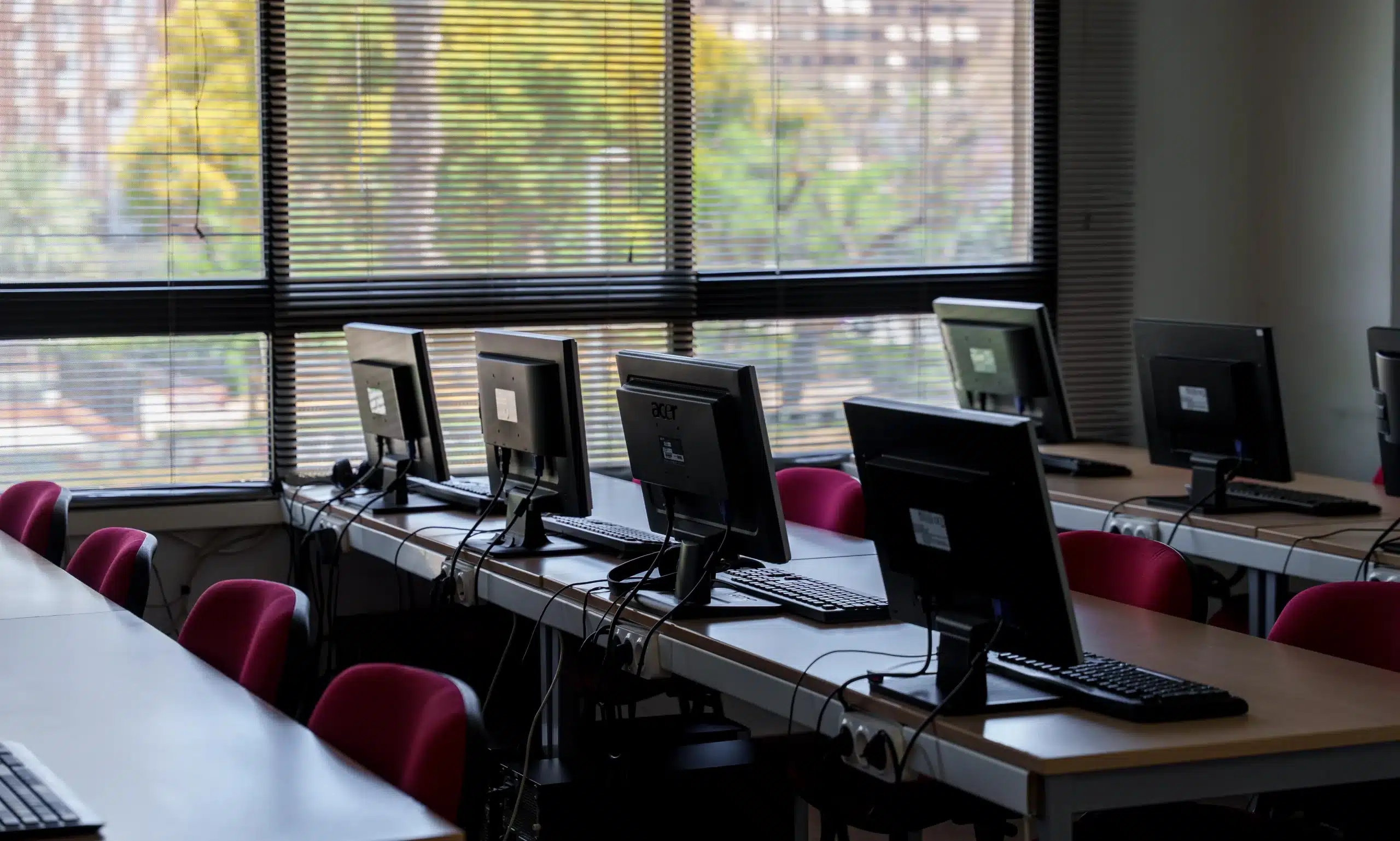Aula de formación con ordenadores y ventanales en Escuela Mastermedia Valencia