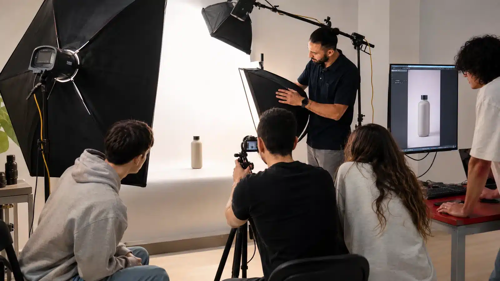Práctica de fotografía de producto con iluminación de estudio, cámara y alumnado en Escuela Mastermedia Valencia